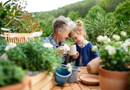 Bien avec les autres, une retraité est dehors avec sa petite-fille, tête contre tête