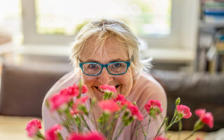 Bien dans mon environnement, une femme souriant derrière un bouquet de fleur